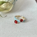 Macro detail of adjustable gold ring with light blue enamel and red gemstones - Red Diamond Blue Base
