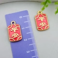Red gold-sand alloy Ping'an charm pendant with 2cm length measurement on purple ruler - Double-Sided Small Safety Square Tag