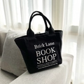 Compact black canvas handbag for lunch or cosmetics featuring Brick Lane Bookshop design - Large Letter Black (Small)