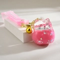 Detail von pinkem Winkekatze Schlüsselanhänger mit flüssigem Glitzereffekt und Glocke - Rosa