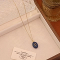 Detail einer blauen ovalen Edelsteinkette mit Goldkette in einer Luxus-Schmuckschatulle - Lapislazuli