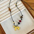 Detail of a golden horse pendant necklace with colorful beads on a premium jewelry box display - Gold Leather Agate Tiger Eye Beaded Slender Horse Necklace