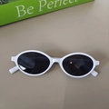 Close-up of white oval kids sunglasses with dark lenses on a minimalist background - Porcelain White