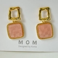 Macro view of gold-plated square earrings featuring a pink checkerboard resin inlay - Wavy Gold Square Pink Checkerboard