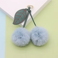 Close-up of light blue plush cherry keychain with green leather leaf and gold metal ring - Spring Ring / Blue