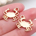 Handcrafted gold crab charms for DIY jewelry making shown on fingertip for scale - Crab Pendant 15x16mm