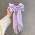 Close-up of a lavender satin oversized bow hair clip with long elegant flowing ribbons - Purple