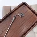 Close-up of vintage silver tassel hairpin with floral pendant on a wooden tray - F0742 Hair Stick-32# (Carved Cone Flower Pendant)