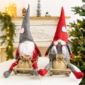 Set of two plush Christmas gnomes on wooden sleds with festive heart-accented hats - Sled Gnomes (Male & Female Pair)