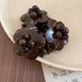 Macro shot of dark brown coconut shell flower beads on a vintage ceramic plate - Flower Style (HB4696) / Coffee