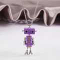 Dettaglio di un ciondolo robot viola con arti mobili e accenti di ingranaggi su velluto - Viola Scuro