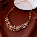 Detalle de un collar de cristal vintage sobre seda marrón con acentos dorados - Collar-Dorado-Marrón