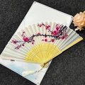 Traditional Chinese folding fan with red plum blossoms, bamboo frame, and white tassel - Smile Red Plum - Off White