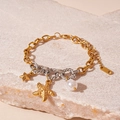 Detail van octopus en zeester bedels aan een gouden metalen ketting met witte parel - Armband - Gouden Zeester