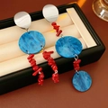 Dettaglio di orecchini pendenti con perle di corallo rosso e dischi in marmo blu stile boho - Ago in Argento-Blu-Rosso