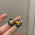 Cute yellow cartoon cat earrings with blue base displayed on hand in natural light - 33# Cartoon Cat Earrings