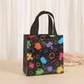 Detail of black non-woven gift bag featuring vibrant colorful ink splash print and stars - Colorful Splatter