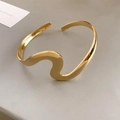 Minimalist polished light gold wavy open bangle bracelet with modern geometric streamlined design - Gold Wave Streamline Style