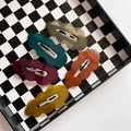 Five wavy dark jelly acrylic hair clips in deep colors on checkered tray - 7cm Wavy Cloud Shape 5PCS