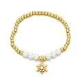 Chic gold beaded bracelet with white pearls and a sparkling snowflake charm on white background - Snowflake Pendant