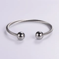 Minimalist silver braided twisted wire bangle with spherical end caps and open design - Steel