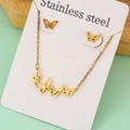 Macro view of gold stainless steel jewelry set featuring hollow butterfly necklace and studs - Hollow Butterfly Set