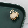 Detail showing gold metal pineapple hair claw clip with textured leaf pattern details - Pineapple / Gold