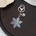 Detail van kleurrijke acryl sneeuwvlok sleutelhanger met iriserende bol en metalen clip - Wit