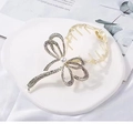 Close-up of golden metal butterfly hair claw with rhinestones and center pearl detail - F0357 Bowtie - Gold