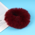 Fuffy faux fur hair scrunchie in burgundy red on a soft blue background for women - Burgundy