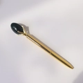 Detail van een gouden metalen balpen met een klauwzetting en donkergroene edelsteen-top - Mosagaat