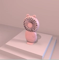 Pink handheld mini fan with cartoon bear ears and USB charging base in 3D render - Cat Cartoon Style / Pink
