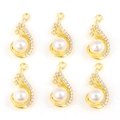 Set di sei ciondoli a goccia in lega dorata con perle e strass su sfondo bianco - A Forma di Goccia / A Forma di Piuma