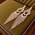 Detailed close-up of luxury silver tassel earrings with sparkling rhinestones on velvet - Gold (925 Sterling Silver Earring Post)