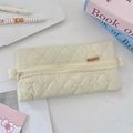 Detailed macro view of beige quilted pencil case with Sozakka label and zipper closure - Beige