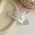 Dettaglio macro di un fermaglio per capelli a tulipano bianco su vassoio ceramico - Artiglio Per Capelli Tulipano Bianco / Sirena Perlata - Stile Giglio