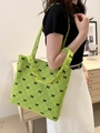 Bolso tote de pana verde neón con diseño de lazo negro llevado por una modelo - Verde
