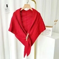 Close-up of red knit poncho featuring twill texture and decorative brown leather buckle - Triangle Style / Red