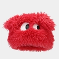 Close-up of fluffy red plush fabric and cartoon big eyes on a cozy winter hat - Red