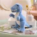 Dinosauro di peluche T-Rex blu su un tavolo in un accogliente soggiorno di casa - 25-28cm / Blu