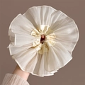 Primer plano de un coletero grande de organza crema con elegantes capas rizadas y tela suave - Blanco Crema