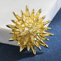 Macro view of gold sunburst brooch featuring radiant yellow multifaceted gemstones - Yellow
