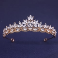 Elegant gold bridal crown with sparkling clear crystals on a textured blue background - Gold