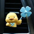 Close-up of cute yellow duck air vent clip with blue propeller on car dashboard - Yellow Duck