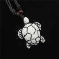 Resin sea turtle pendant necklace with black cord and brown wooden beads on black background - White