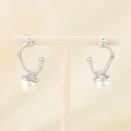 Detailed shot of French vintage silver bow earrings with white pearls on a display stand - Steel Streamlined (KE113304-KFC)