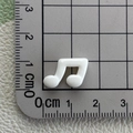 Close-up of a white glossy musical note resin charm measured on a cutting mat scale - White