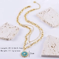 Detail of gold double-layer necklace with pearl and turquoise sun pendant on stone - Necklace