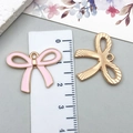 Pink enamel bow pendant with gold hollow design and ruler for size scale reference - Large KC Gold Pink Hollow Bowknot