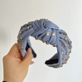Detail of light blue knotted headband featuring sparkling rhinestones and gold studs - Blue